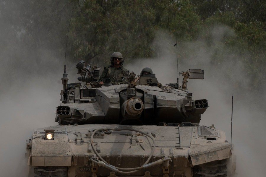 Israeli soldiers move on the top of a tank near the Israeli-Gaza border, as seen from southern Israel, Thursday, April 25, 2024. (AP Photo/Leo Correa)