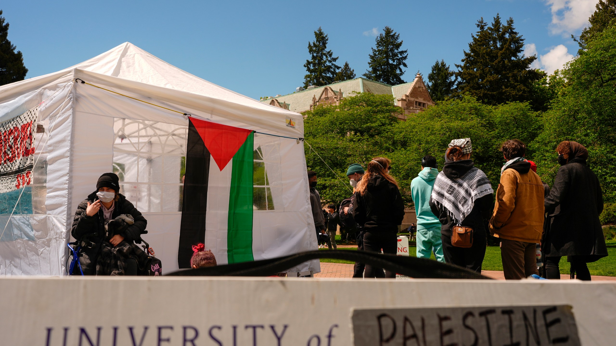 A sign is shown written over to read "University of Palestine" at a pro-Palestinian encampment on the University of Washington campus Monday, April 29, 2024, in Seattle. The group is demanding that the university divest from Israel and cut ties with Boeing, which manufactures products used by Israel Defense Forces. (AP Photo/Lindsey Wasson)