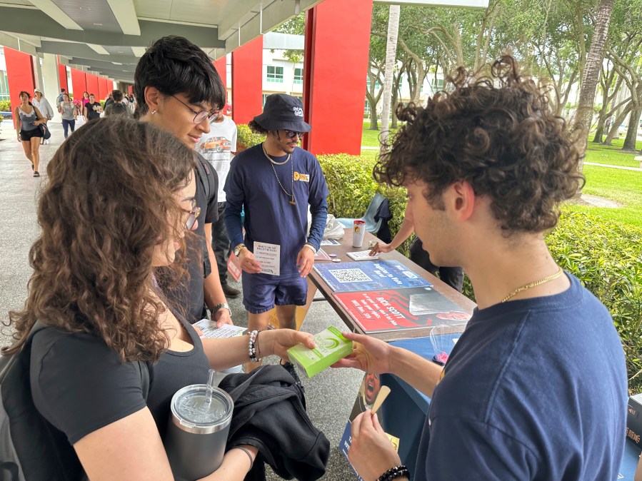 College students pass out Plan B to educate young voters at Florida Atlantic University on Thursday, April 11, 2024, in Boca Raton, Fla. Abortion and marijuana will be on Florida's November ballot, and these issues are critical issues for young voters. (AP Photo/Cody Jackson)