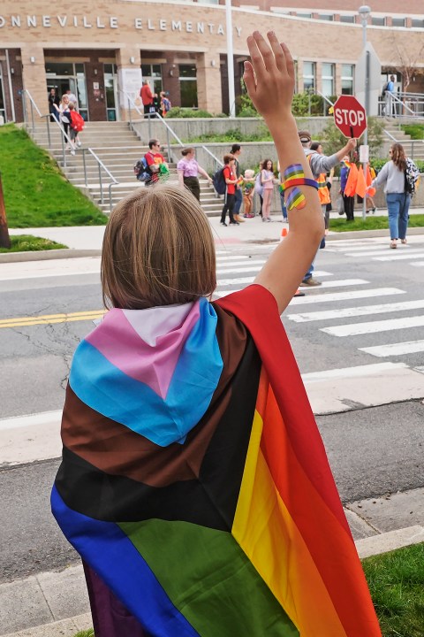 Bonneville Elementary School 5th grader Graham Beeton, waves to fellow students during a block party supporting trans and non binary students and staff Monday, April 29, 2024, in Salt Lake City. Utah will become the latest state to implement restrictions for transgender people using school bathrooms and locker rooms in public schools and government-owned buildings when key components of a law passed by the Republican controlled Legislature take effect May 1. (AP Photo/Rick Bowmer)