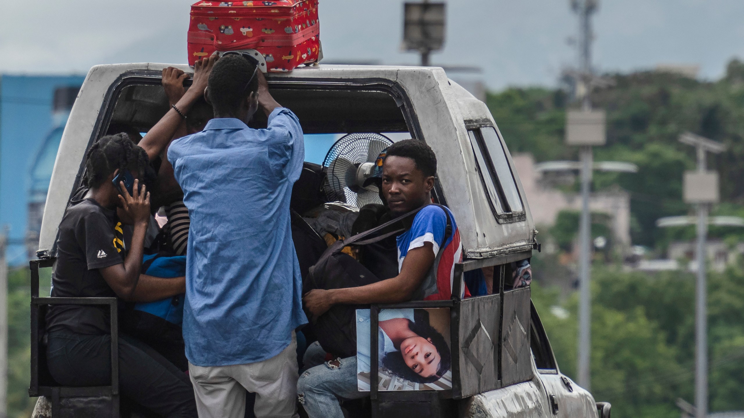 Residents use a public transport vehicle known as a tap-tap as they evacuate from the Delmas 22 neighborhood, with luggage and photos, to escape gang violence in Port-au-Prince, Haiti, Thursday, May 2, 2024. (AP Photo/Ramon Espinosa)