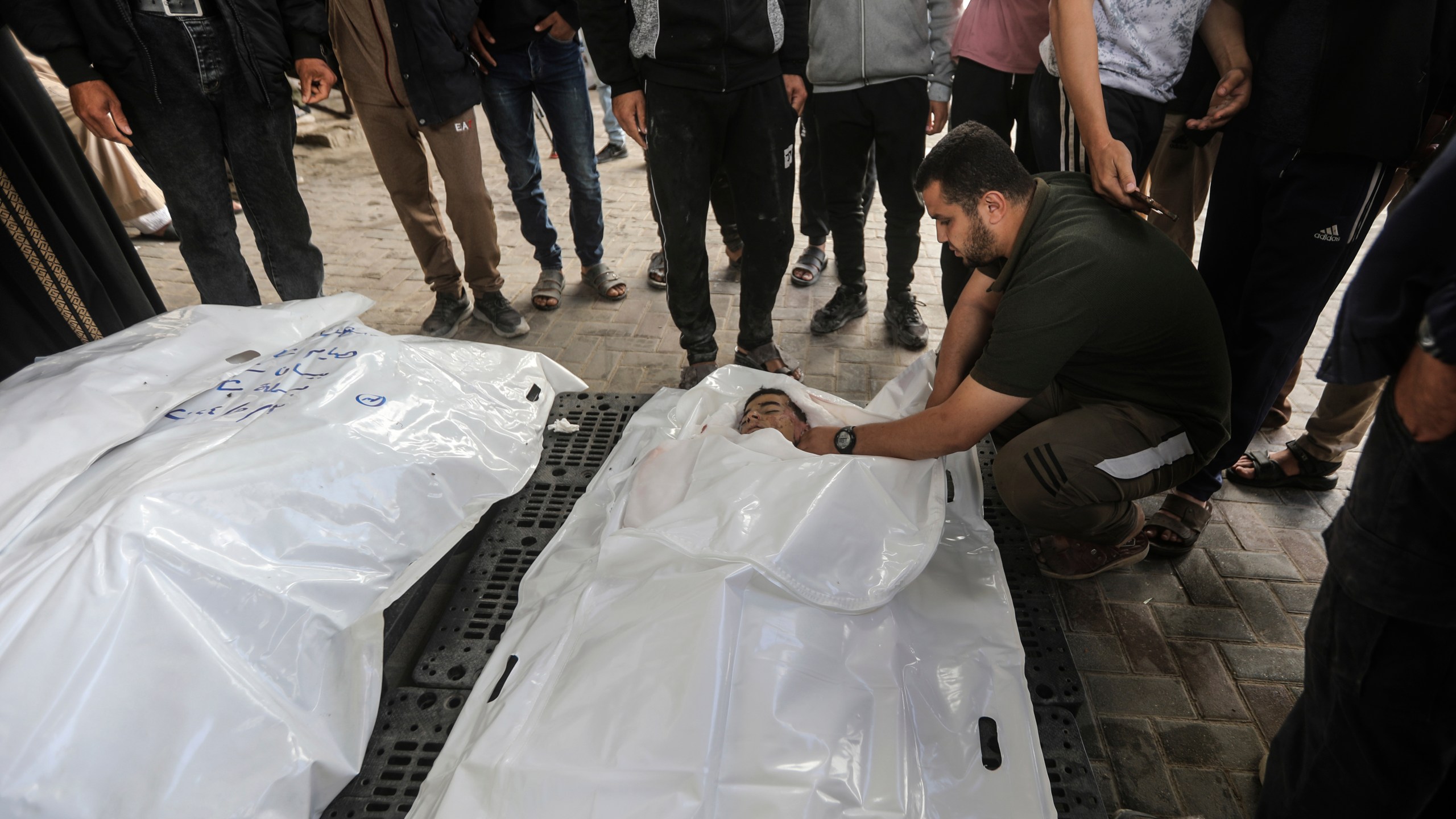 The Chahine family prepares to bury two adults and five boys and girls under the age of 16 after an overnight Israeli strike in Rafah, southern Gaza Strip, Friday, May 3, 2024. An Israeli strike on the city of Rafah on the southern edge of the Gaza Strip killed several people, including children, hospital officials said Friday. (AP Photo/Ismael Abu Dayyah)