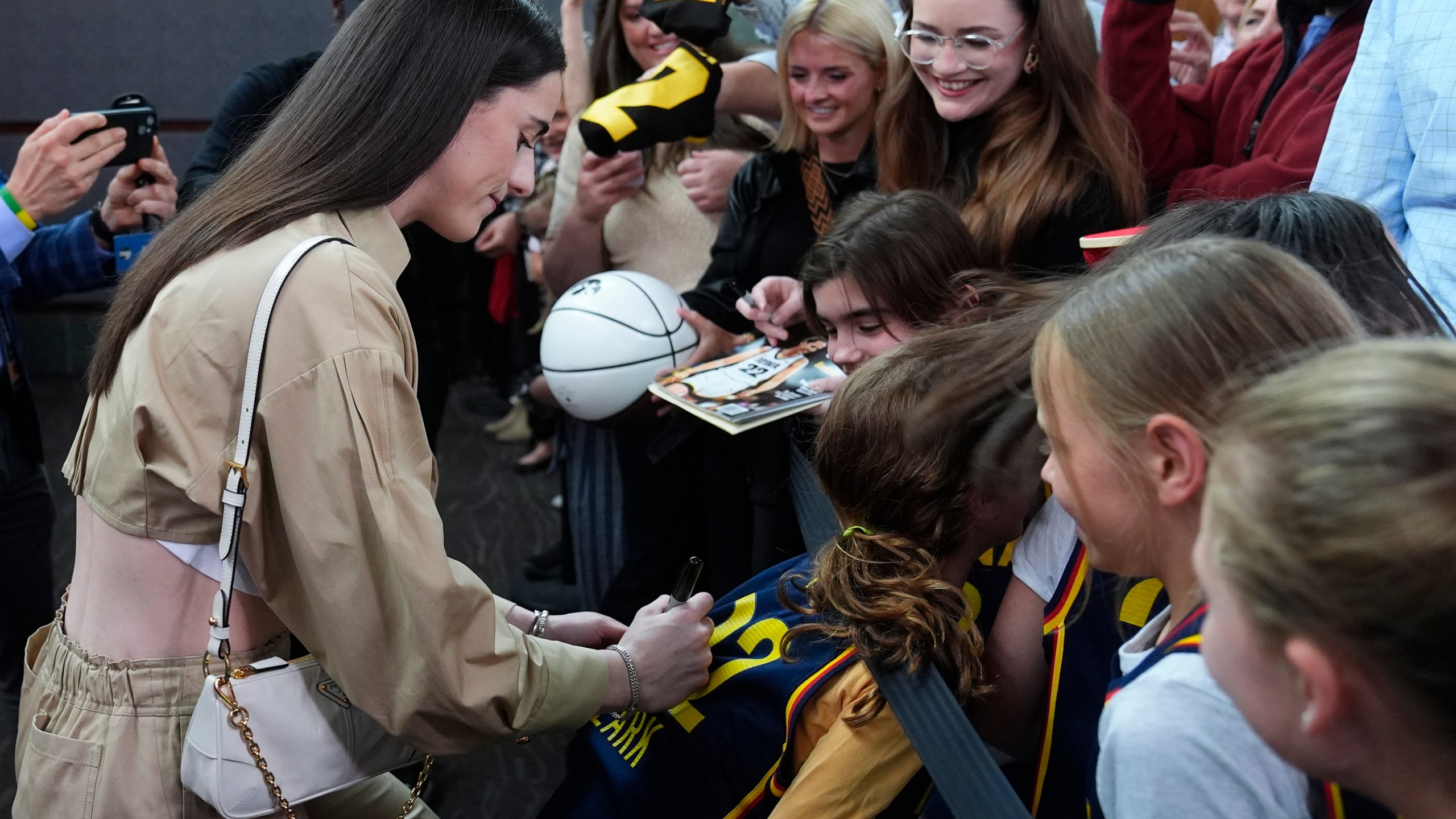 Indiana Fever's Caitlin Clark, left, gives autographs as she arrives on the Red Carpet before the world premiere and screening of Episode 1 of the upcoming ESPN+ Original Series Full Court Press, Monday, May 6, 2024, in Indianapolis. (AP Photo/Darron Cummings)