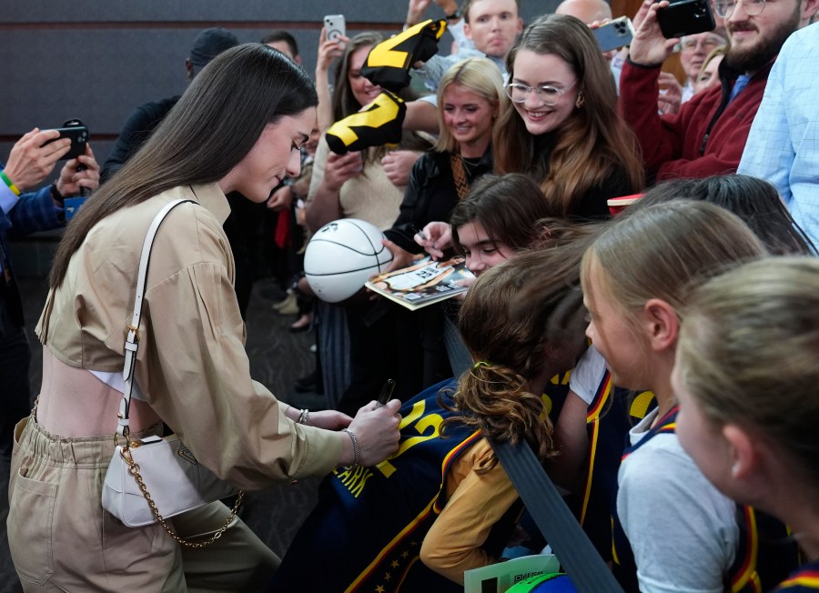 Indiana Fever's Caitlin Clark, left, gives autographs as she arrives on the Red Carpet before the world premiere and screening of Episode 1 of the upcoming ESPN+ Original Series Full Court Press, Monday, May 6, 2024, in Indianapolis. (AP Photo/Darron Cummings)