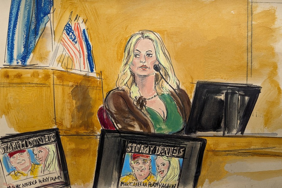 Stormy Daniels testifies on the witness stand as a promotional image for one of her shows featuring an image of Trump is displayed on monitors in Manhattan criminal court, Thursday, May 9, 2024, in New York. (Elizabeth Williams via AP)