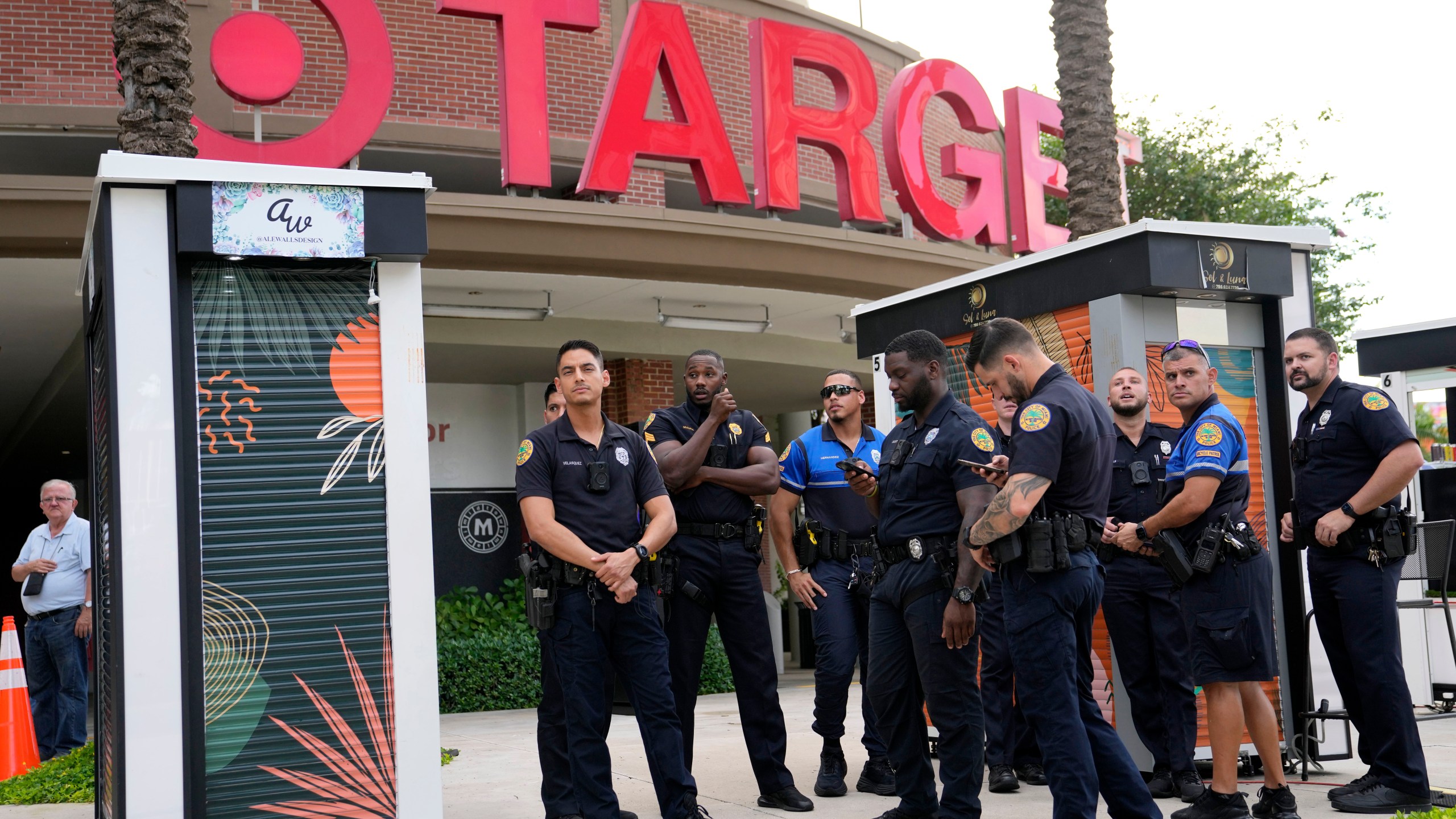 FILE - Police officers stand outside of a Target store as a group of people across the street protest against Pride displays in the store on June 1, 2023, in Miami. Target confirmed that it won't be carrying its LGBTQ+ merchandise for Pride month in June, 2024, in some stores after the discount retailer received backlash last year for its assortment. (AP Photo/Lynne Sladky, File)