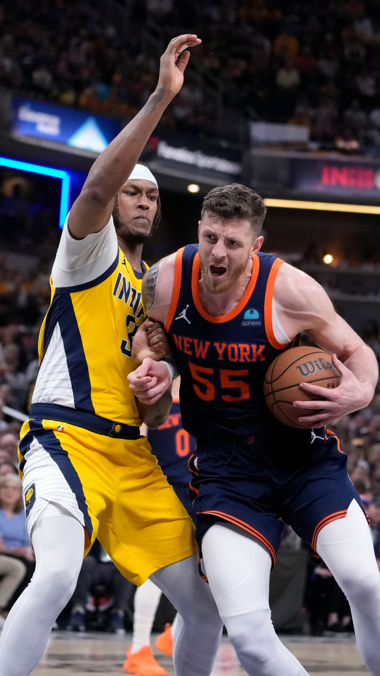 New York Knicks center Isaiah Hartenstein (55) drives past Indiana Pacers center Myles Turner, left, during the first half of Game 4 in an NBA basketball second-round playoff series, Sunday, May 12, 2024, in Indianapolis. (AP Photo/Michael Conroy)