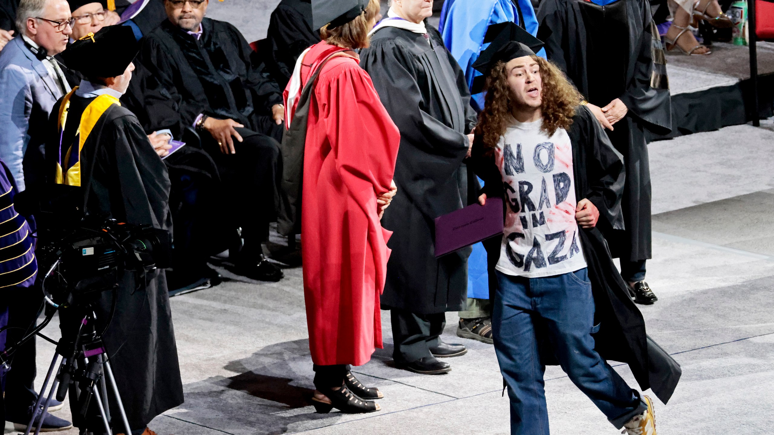 A graduate displays a message on his shirt, "No Grad in Gaza," during the Emerson College commencement ceremony at Boston University's Agganis Arena, Sunday, May 12, 2024, in Boston. Many students verbally protested throughout the ceremony. (Pat Greenhouse/The Boston Globe via AP)