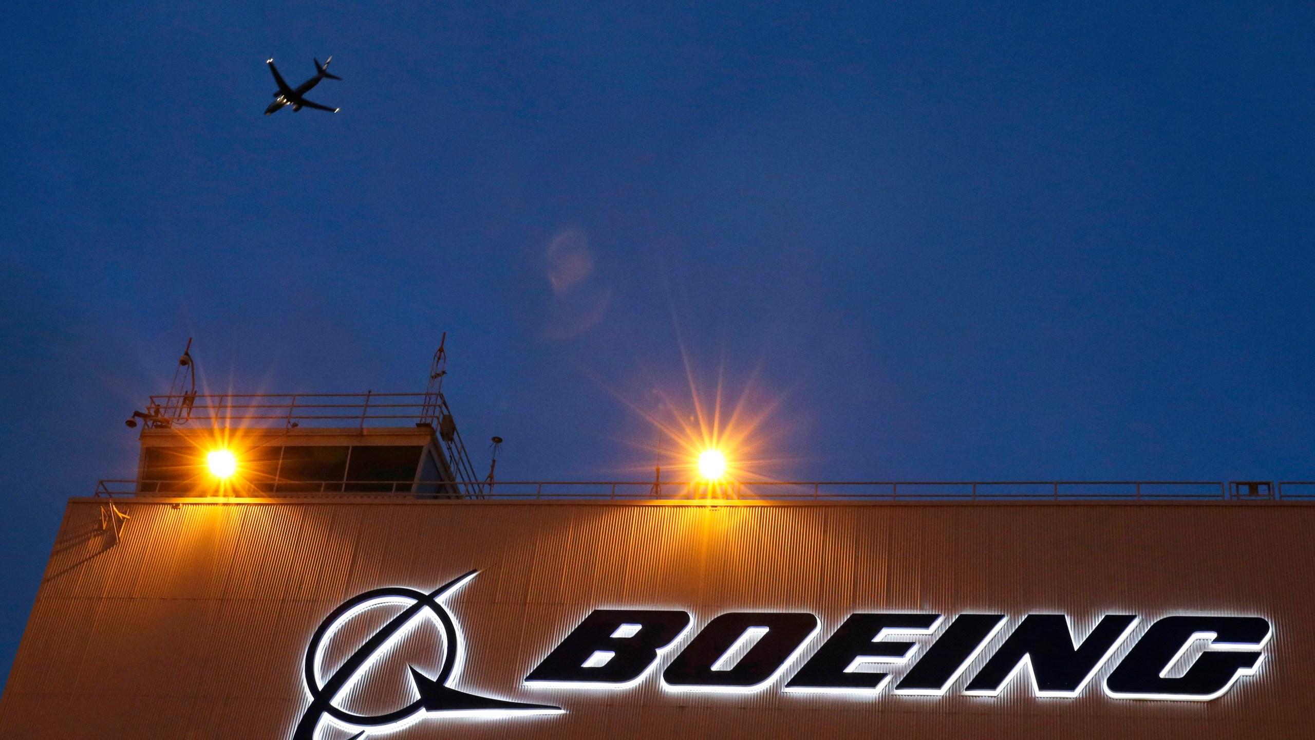 FILE - An airplane flies over a sign on Boeing's 737 delivery center, Oct. 19, 2015, at Boeing Field in Seattle. The Justice Department's determination on Tuesday, May 14, 2024, that Boeing violated corporate probation for deceiving federal regulators does not necessarily mean that prosecutors will revive criminal charges against the giant aircraft manufacturer. (AP Photo/Ted S. Warren, File)