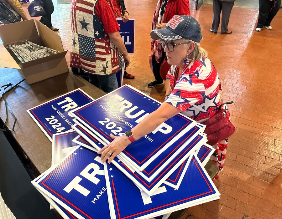 Ginger Hurmence of Lincolnton, Ga., picks up Republican presidential candidate Donald Trump yard signs at the Georgia Republican Party State Convention in Columbus, Ga., on Saturday, May 18, 2024. (AP Photo/Jeff Amy)