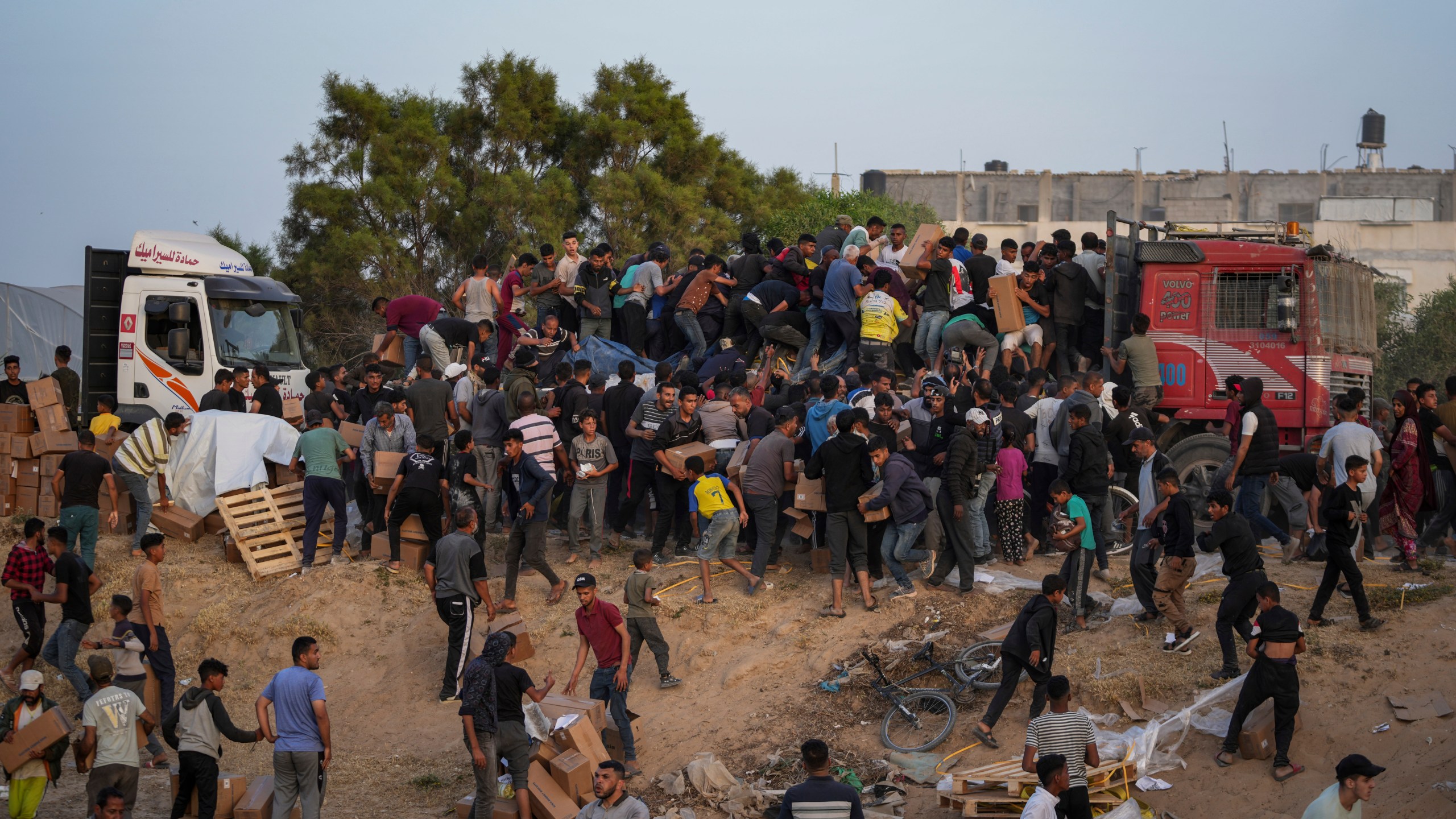 Palestinians storm trucks loaded with humanitarian aid brought in through a new U.S.-built pier, in the central Gaza Strip.