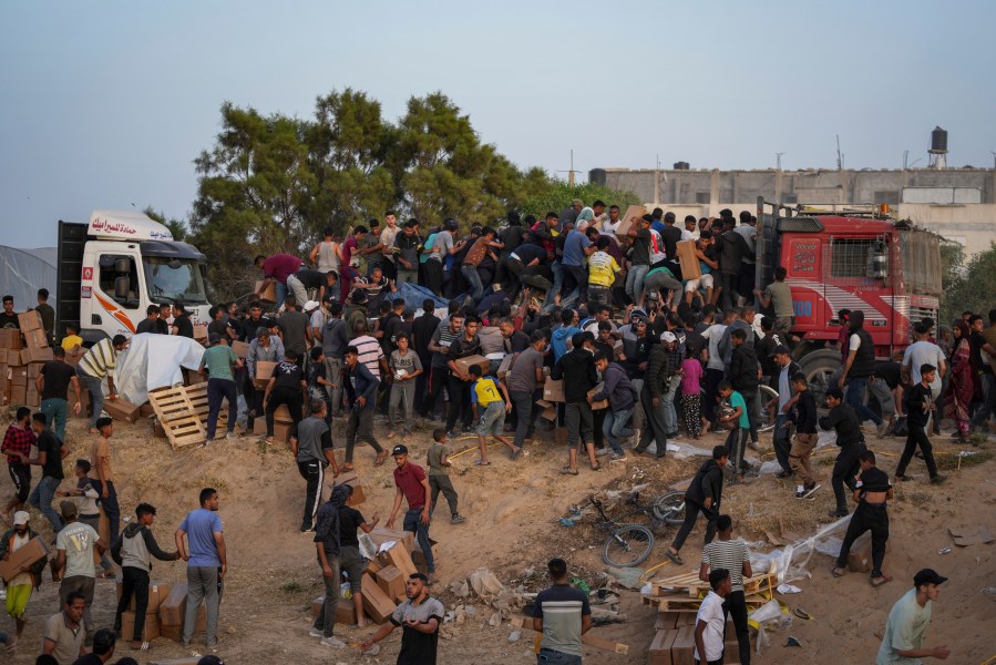 Palestinians storm trucks loaded with humanitarian aid brought in through a new U.S.-built pier, in the central Gaza Strip.