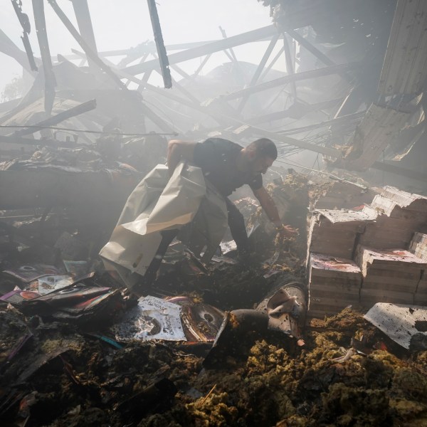 A rescuer recovers a lifeless body from under the rubble after a Russian missile hit a printing house in Kharkiv, Ukraine.