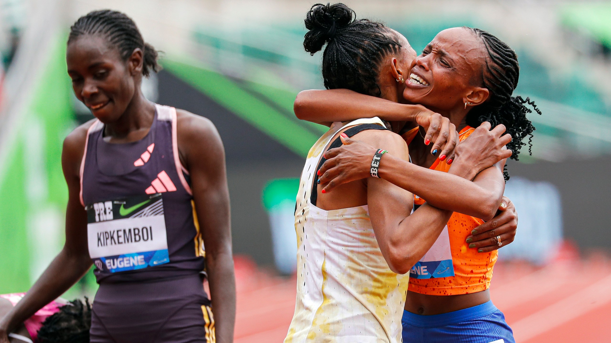 Beatrice Chebet of Kenya, celebrates her world record in the 10,000 with a time of 28:54.14, during the Prefontaine Classic track and field meet Saturday, May 25, 2024, in Eugene, Ore. Gudaf Tsegay, left, of Ethiopia came in second and celebrates with Chebet. (AP Photo/Thomas Boyd)