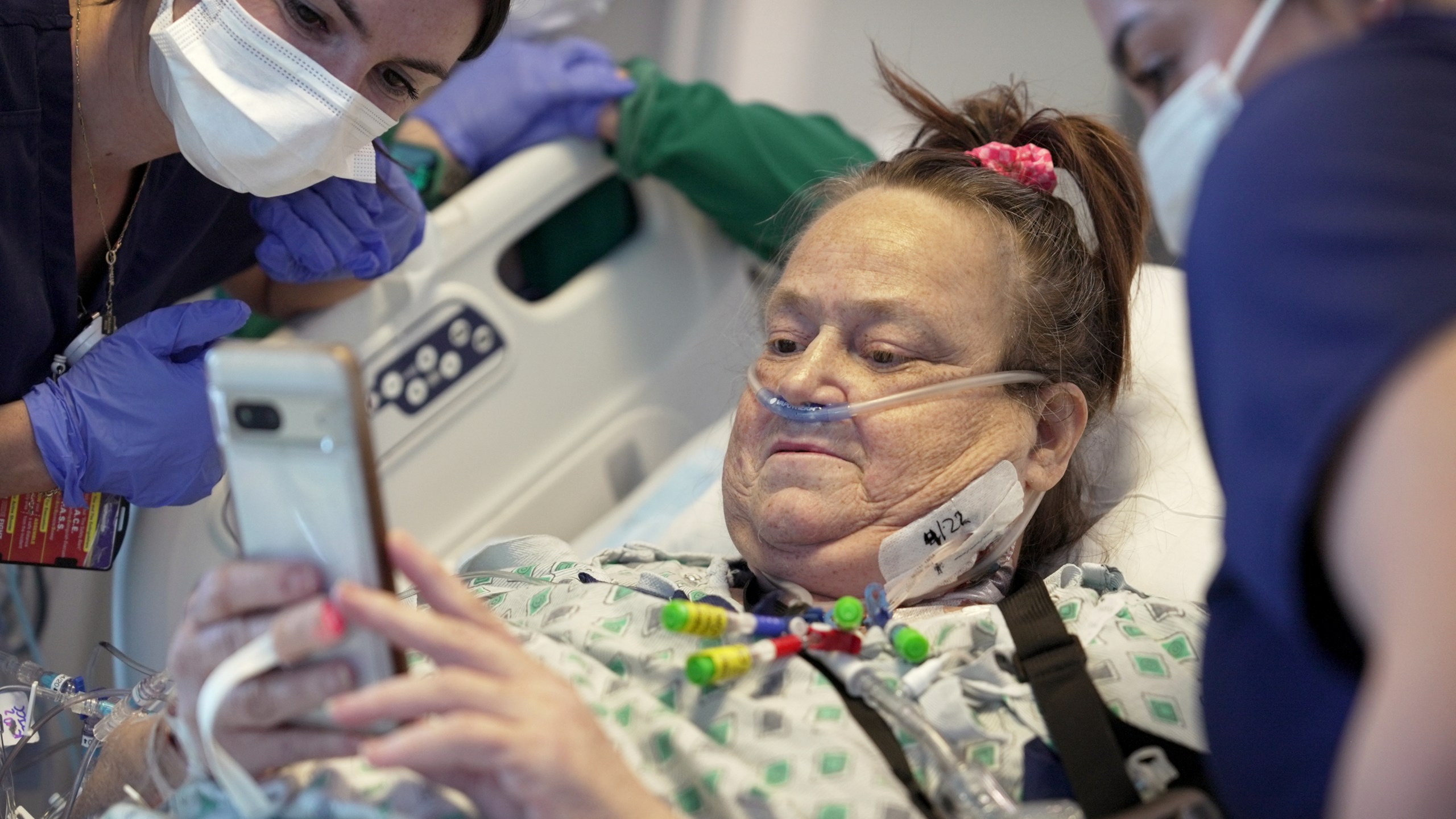 FILE - Lisa Pisano looks at photos of her dog after her surgeries at NYU Langone Health in New York on Monday, April 22, 2024. Doctors had to remove a transplanted pig kidney from Pisano and put her back on dialysis just 47 days later – because the heart disease she also suffers damaged the new organ. Pisano was only the second patient ever to receive a kidney from a gene-edited pig, and NYU Langone Health announced Friday, May 31, that she is stable after removal of the kidney. (AP Photo/Shelby Lum, File)