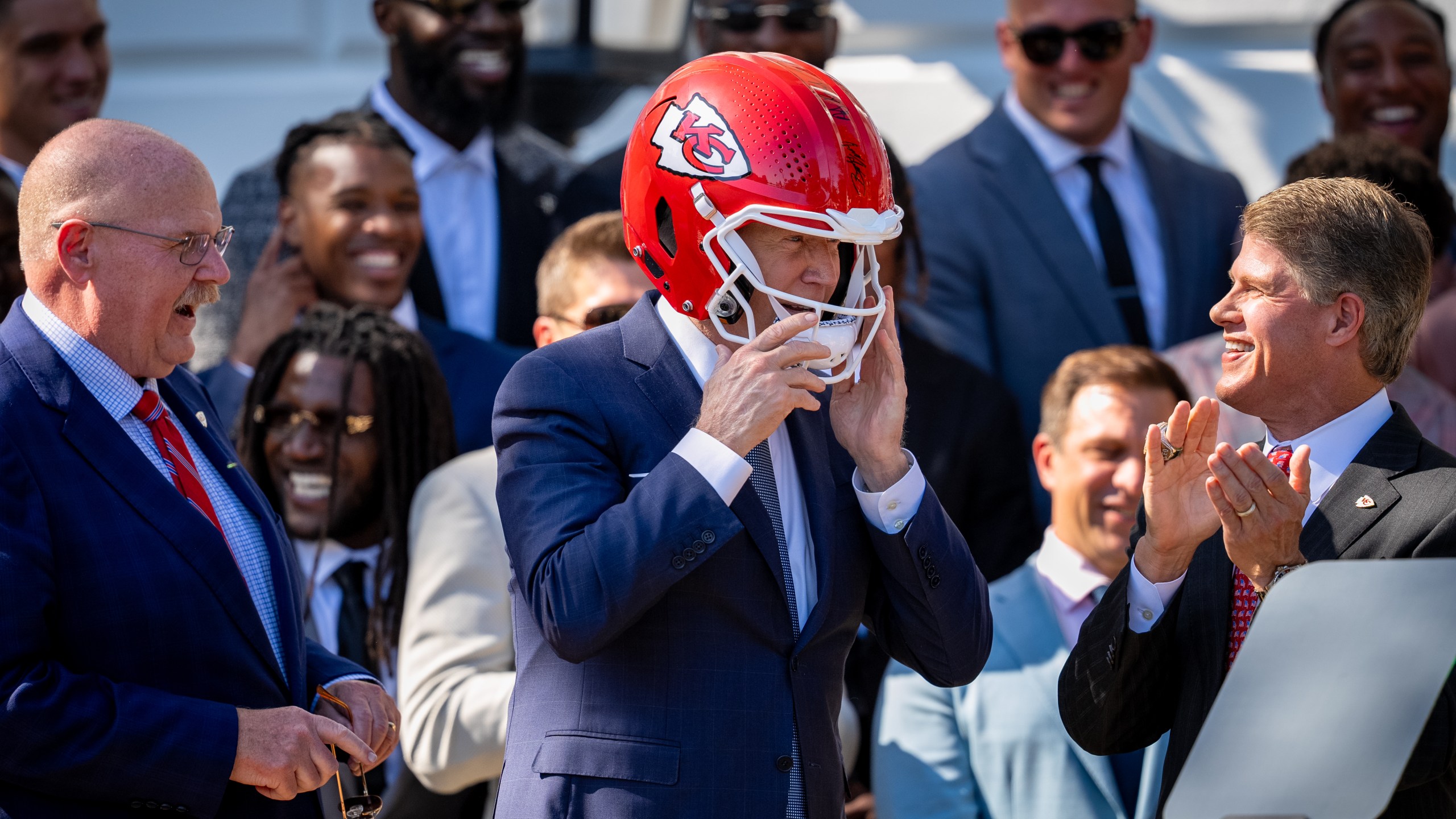 President Biden Hosts Super Bowl Champion Kansas City Chiefs At White House WASHINGTON, DC - MAY 31: Kansas City Chiefs coach Andy Reid (L) and CEO Clark Hunt (R) react as U.S. President Joe Biden puts on a team helmet presented to him during an event on the South Lawn of the White House on May 31, 2024 in Washington, DC. President Biden hosted the Chiefs to honor their 2024 Super Bowl win. (Photo by Andrew Harnik/Getty Images)