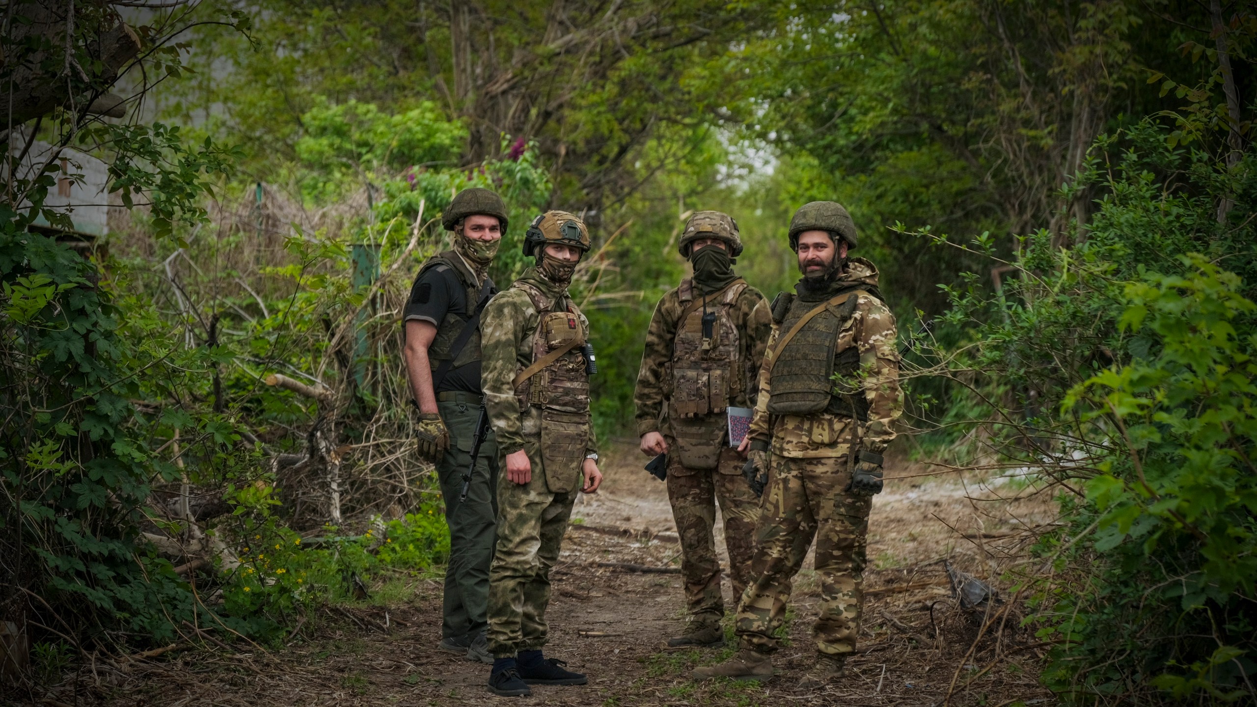 In this photo taken on Friday, April 26, 2024 and released by the Russian Defense Ministry Press Service, Russian soldiers look at a photographer near their position in an undisclosed location in Ukraine. (Russian Defense Ministry Press Service via AP)