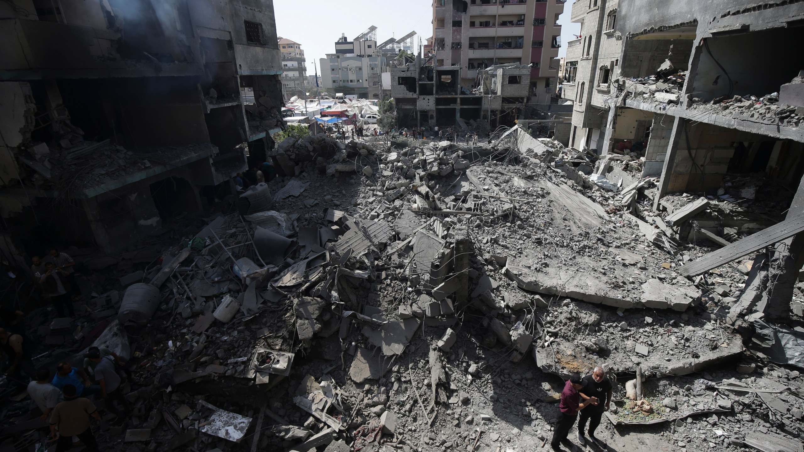 Palestinians look at the aftermath of the Israeli bombing in Nuseirat refugee camp, Gaza Strip, Saturday, June 8, 2024. (AP Photo/Jehad Alshrafi)