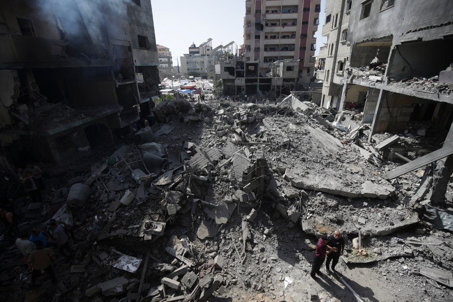 Palestinians look at the aftermath of the Israeli bombing in Nuseirat refugee camp, Gaza Strip, Saturday, June 8, 2024. (AP Photo/Jehad Alshrafi)