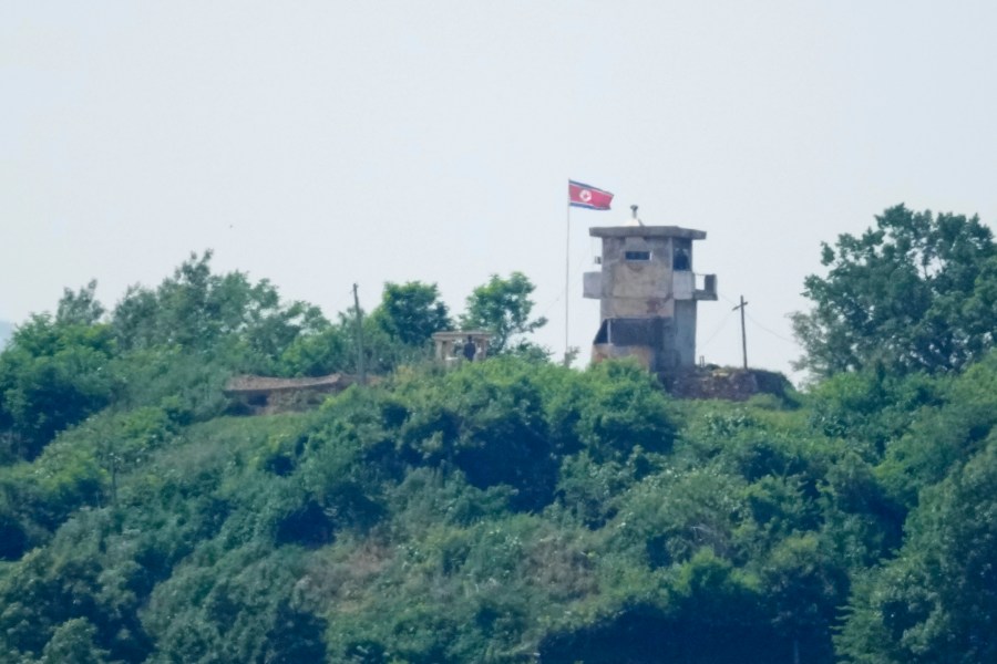 North Korean soldiers stand near their military guard post as a North Korean flag flutters in the wind, seen from Paju, South Korea, Sunday, June 9, 2024. South Korean soldiers fired warning shots after North Korean troops briefly violated the tense border earlier this week, South Korea's military said Tuesday, as the rivals are embroiled in Cold War-style campaigns like balloon launches and propaganda broadcasts. (AP Photo/Lee Jin-man)