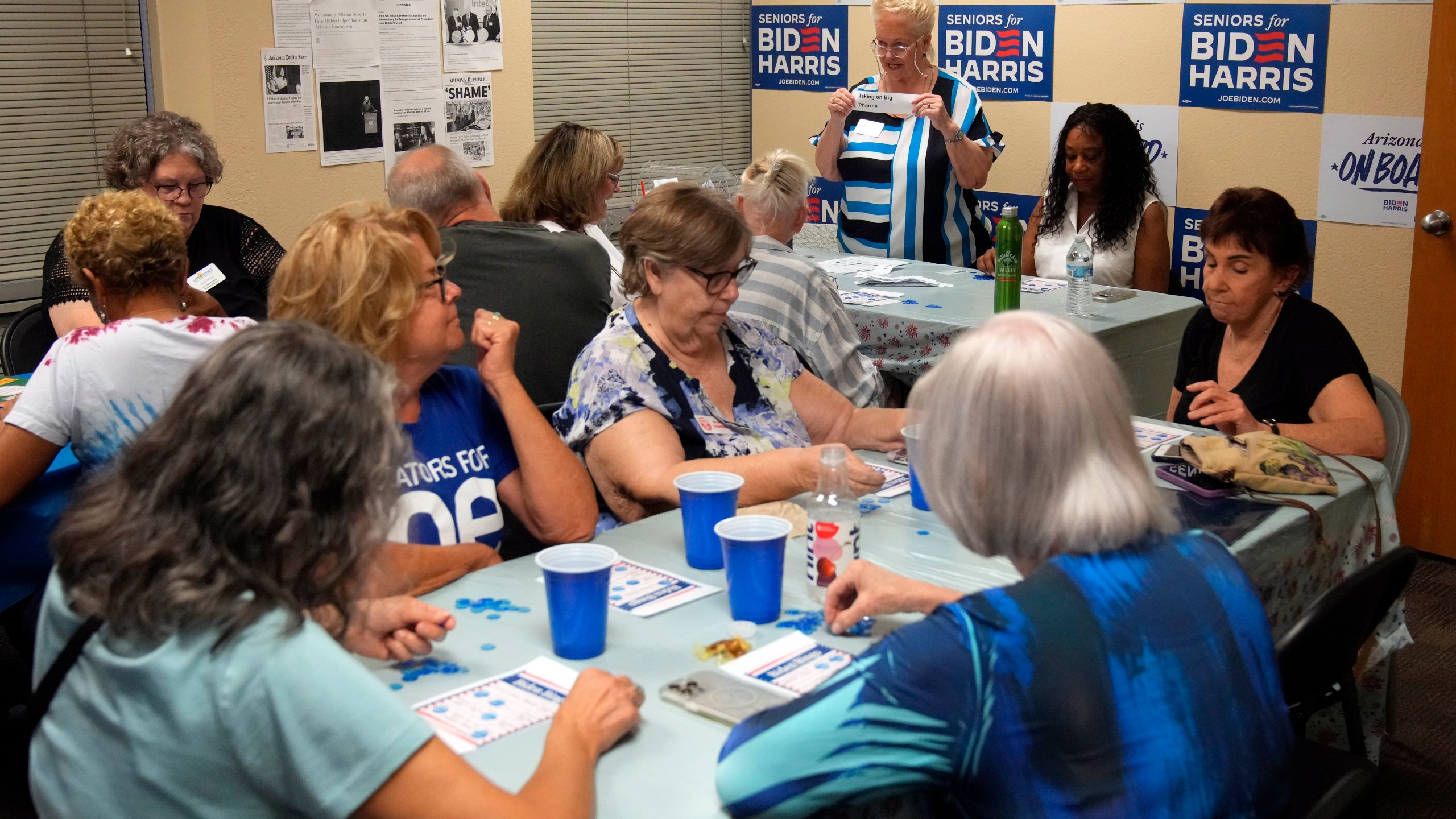 DeAnna Mireau, top, calls out the subjects during a game of bingo at a campaign event for seniors in support of President Joe Biden's reelection campaign, Thursday, June 13, 2024, in Phoenix. (AP Photo/Rick Scuteri)