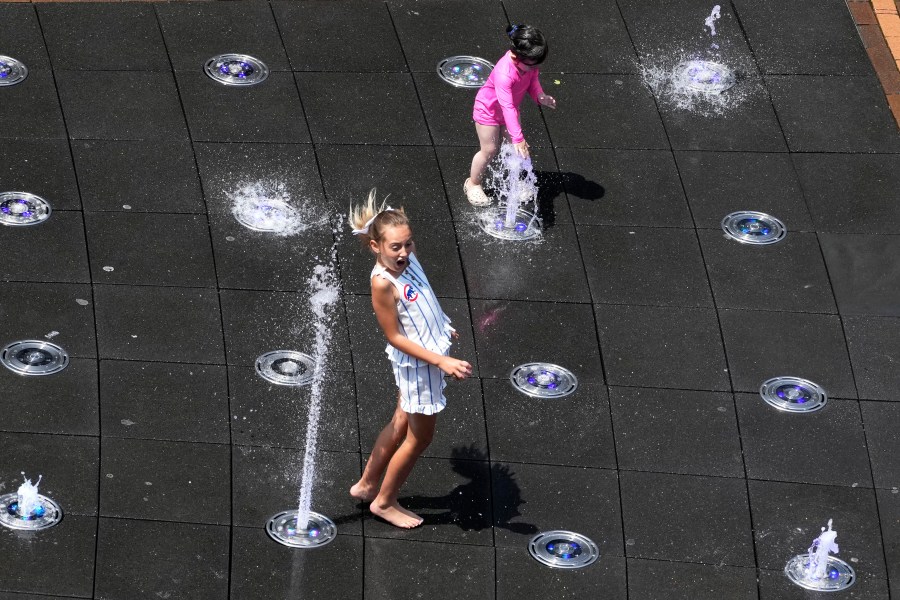 Kids cool off at Gallagher Way park fountain during hot weather in Chicago, Sunday, June 16, 2024. (AP Photo/Nam Y. Huh)