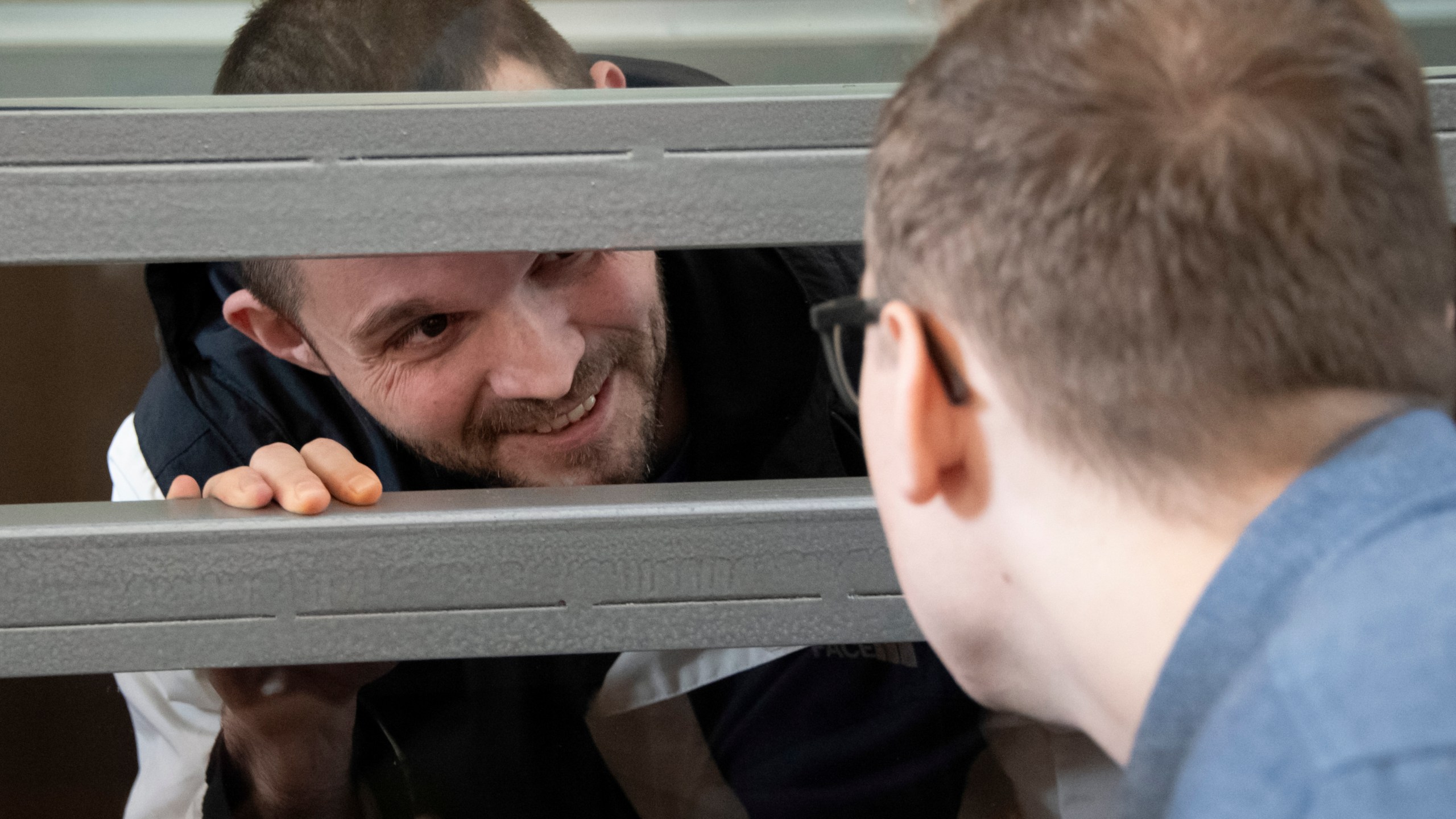 U.S. Army Staff Sgt. Gordon Black talks with his lawyer sitting in a glass cage in courtroom in Vladivostok, Russia, on Wednesday, June 19, 2024. Black is on trial on charges of theft and threatening murder in a dispute with a Russian woman. Russian state media reported that he denied the allegation of threatening murder but "partially" admitted to theft. (AP Photo)