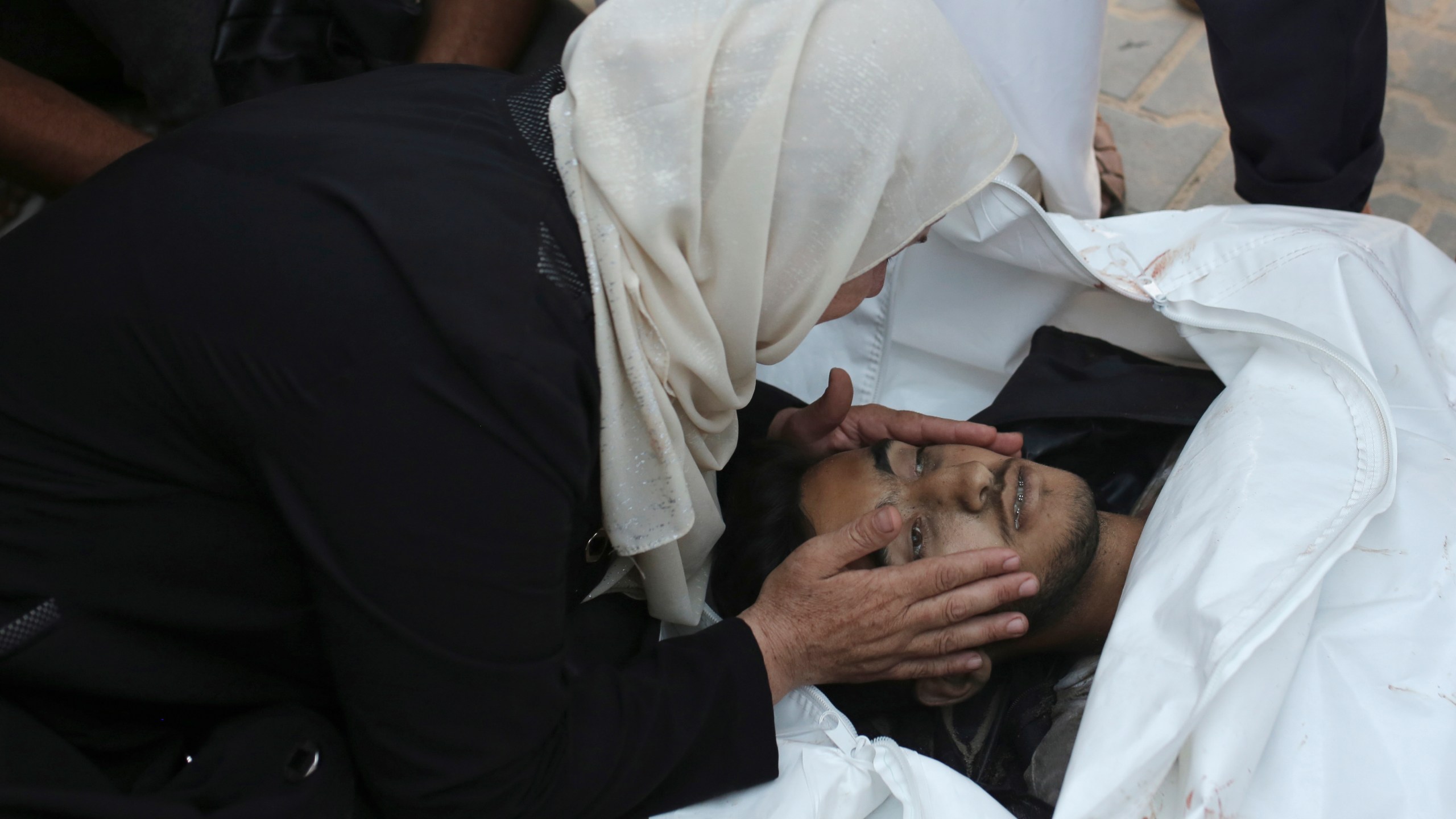 A Palestinian woman takes a last look at a loved one killed by Israeli bombardment, before his burial in Khan Younis, southern Gaza Strip, Friday, June 21, 2024. (AP Photo /Jehad Alshrafi)