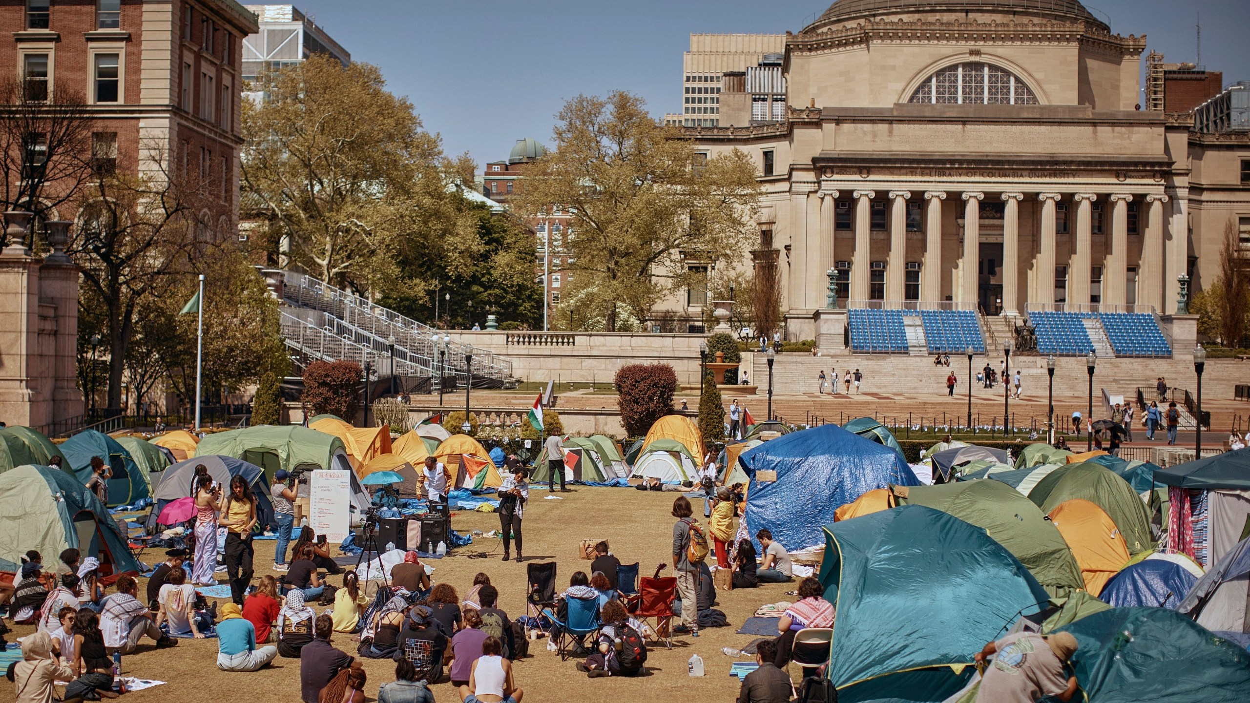 People listen to speaker at pro-Palestinian encampment at Columbia University calling for permanent cease-fire in Gaza.