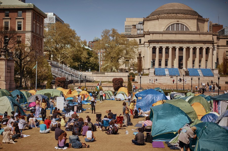 People listen to speaker at pro-Palestinian encampment at Columbia University calling for permanent cease-fire in Gaza.