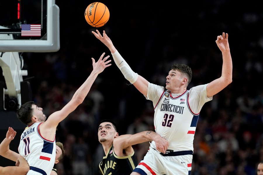 FILE - UConn center Donovan Clingan (32) reaches for the ball as Purdue center Zach Edey defends during the second half of the NCAA college Final Four championship basketball game, Monday, April 8, 2024, in Glendale, Ariz. Clingan is considered to be among the top prospects in this month’s NBA draft. (AP Photo/Brynn Anderson, File)