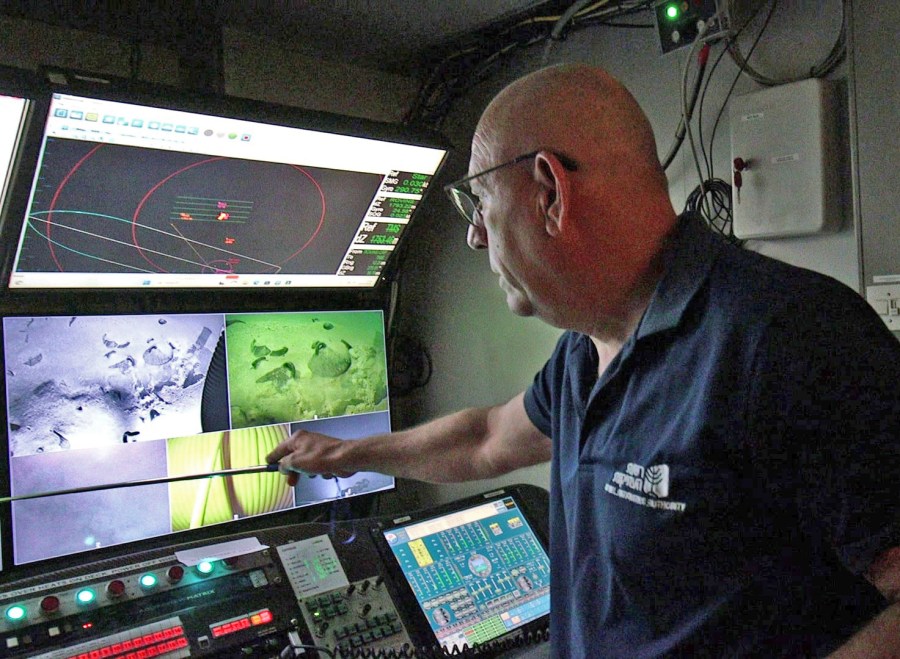 A man in a control room of a ship.