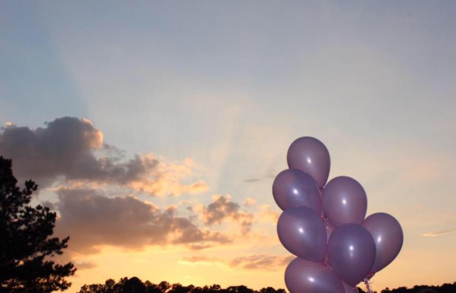 Purple balloons launching into the sky.