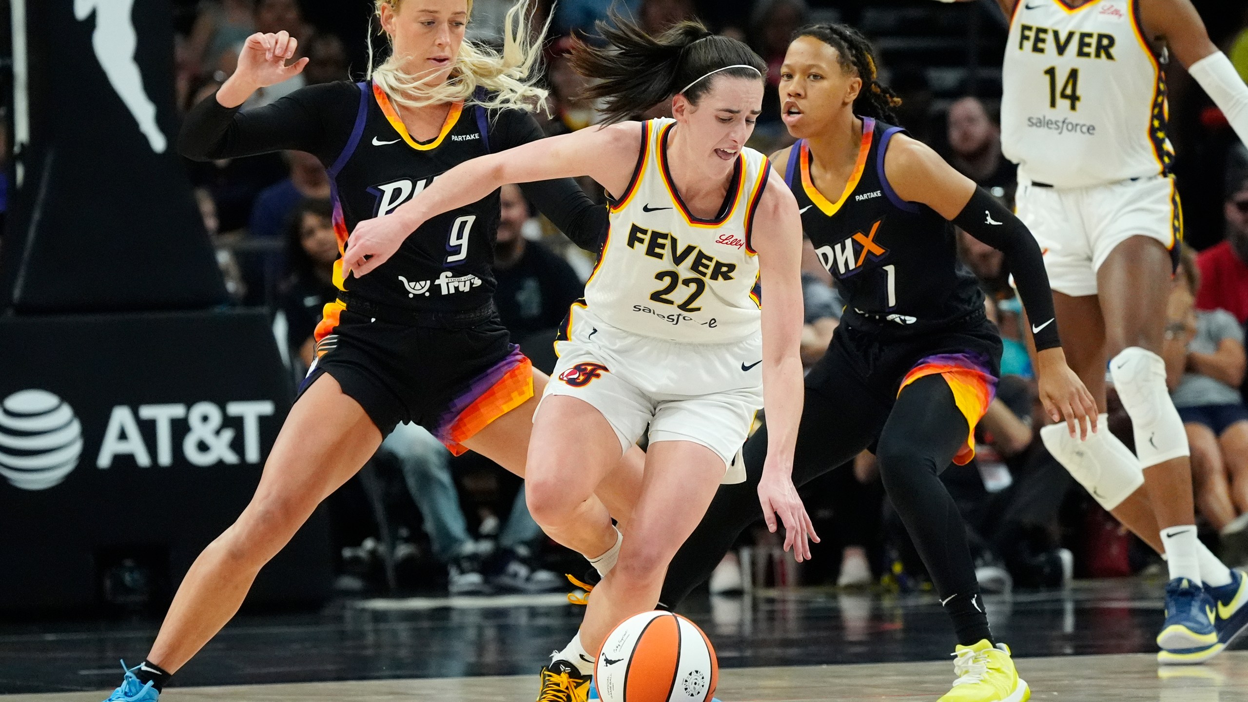 Indiana Fever guard Caitlin Clark (22) is defended by Phoenix Mercury guards Sophie Cunningham (9) and Sug Sutton (1) during the second half of a WNBA basketball game Sunday, June 30, 2024, in Phoenix. (AP Photo/Ross D. Franklin)