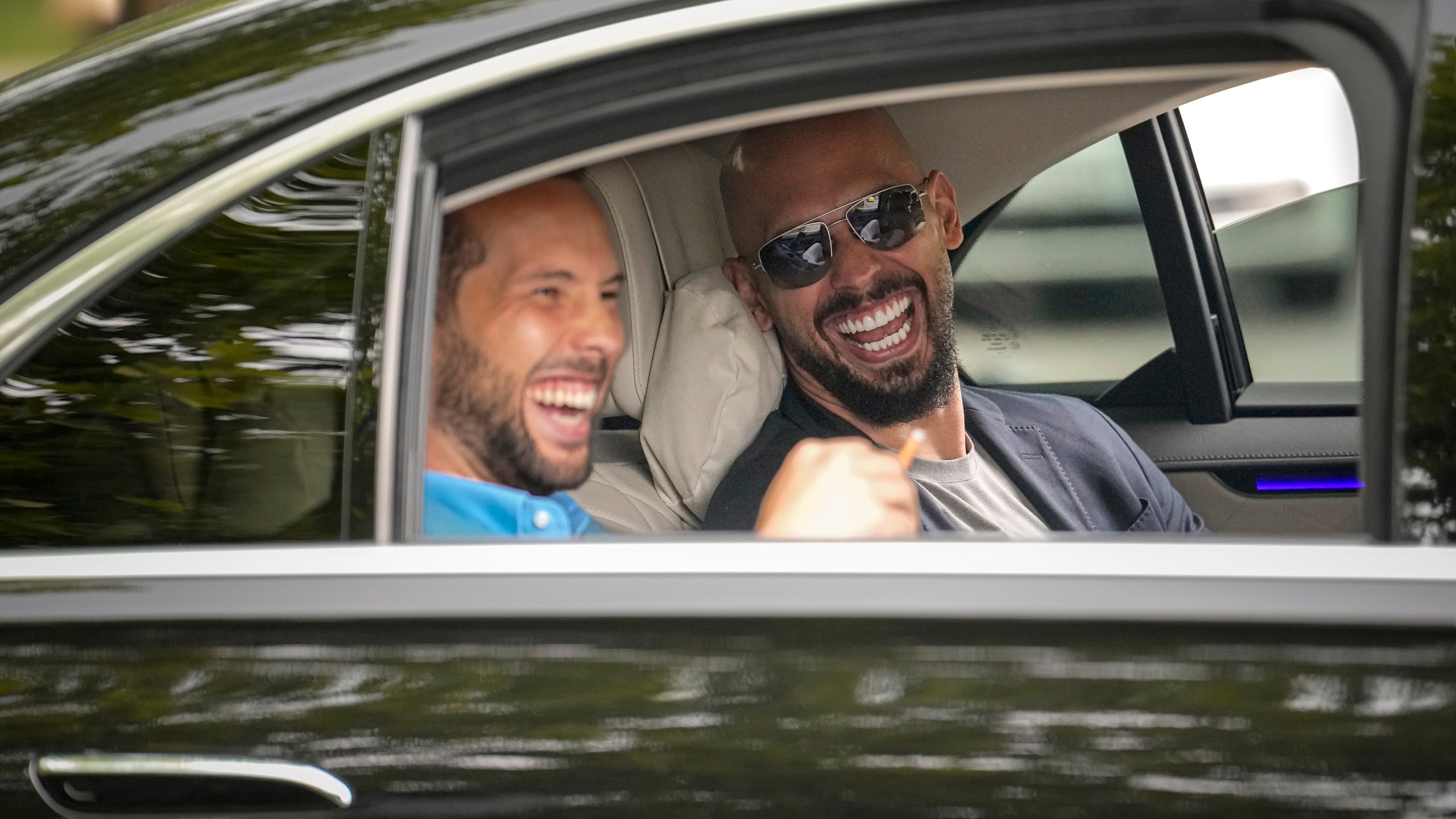 FILE - Andrew Tate, right, and his brother Tristan laugh as they leave the Bucharest Tribunal in Bucharest, Romania, Wednesday, May 8, 2024. A court in Romania's capital on Friday, July 5, 2024 ruled that the online influencer Andrew Tate can leave Romanian territory providing he remains within the European Union, as he awaits trial on charges of human trafficking, rape and forming a criminal gang to sexually exploit women. (AP Photo/Vadim Ghirda, File)