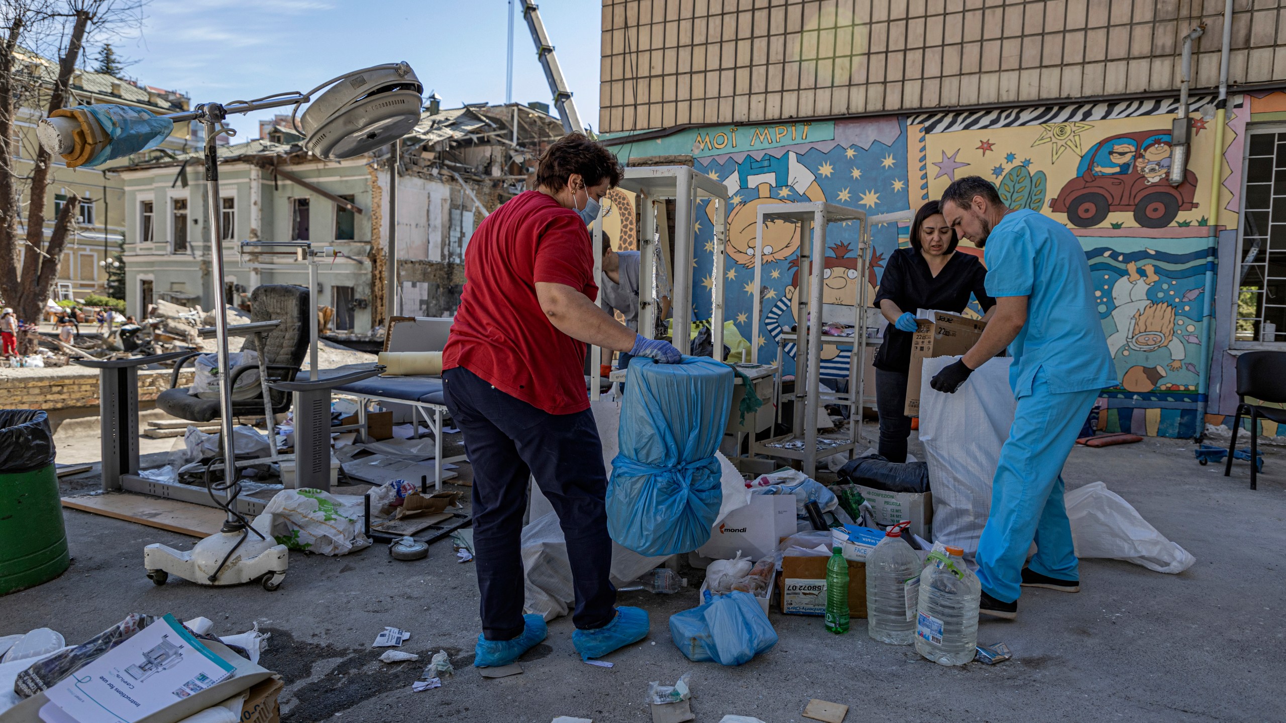 Workers try to salvage intact medical equipment in the hospital yard at the site of Okhmatdyt children's hospital hit by Russian missiles on Monday, in Kyiv, Ukraine, Tuesday, July 9, 2024. (AP Photo/Anton Shtuka)