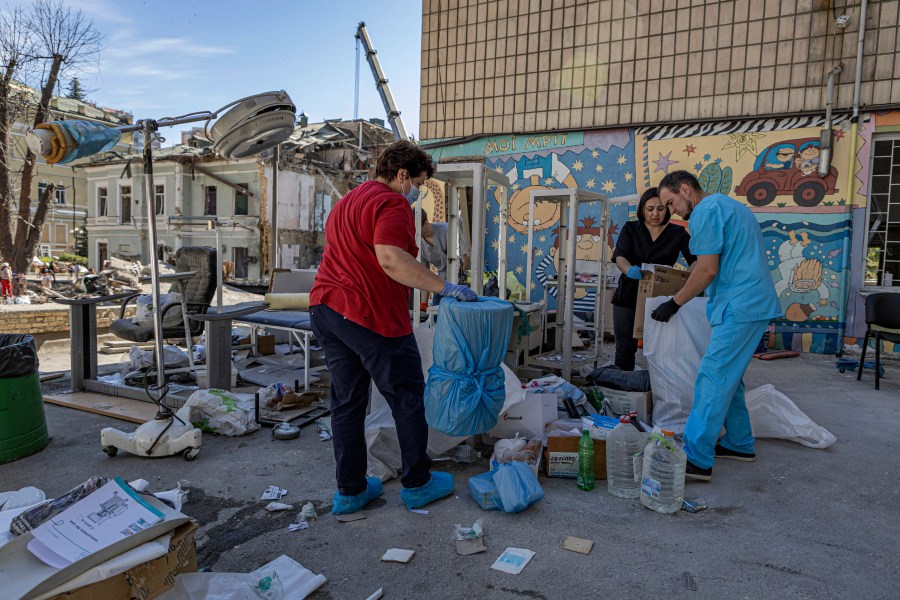 Workers try to salvage intact medical equipment in the hospital yard at the site of Okhmatdyt children's hospital hit by Russian missiles on Monday, in Kyiv, Ukraine, Tuesday, July 9, 2024. (AP Photo/Anton Shtuka)