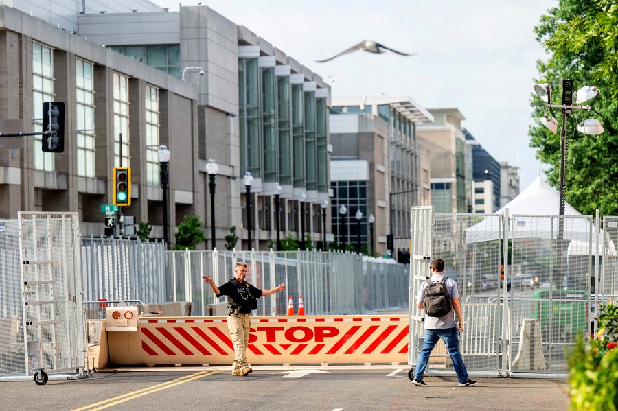 A U.S. Secret Service agent directs a pedestrian around a security perimeter at the NATO summit, in Washington, Wednesday, July 10, 2024. (AP Photo/Noah Berger)