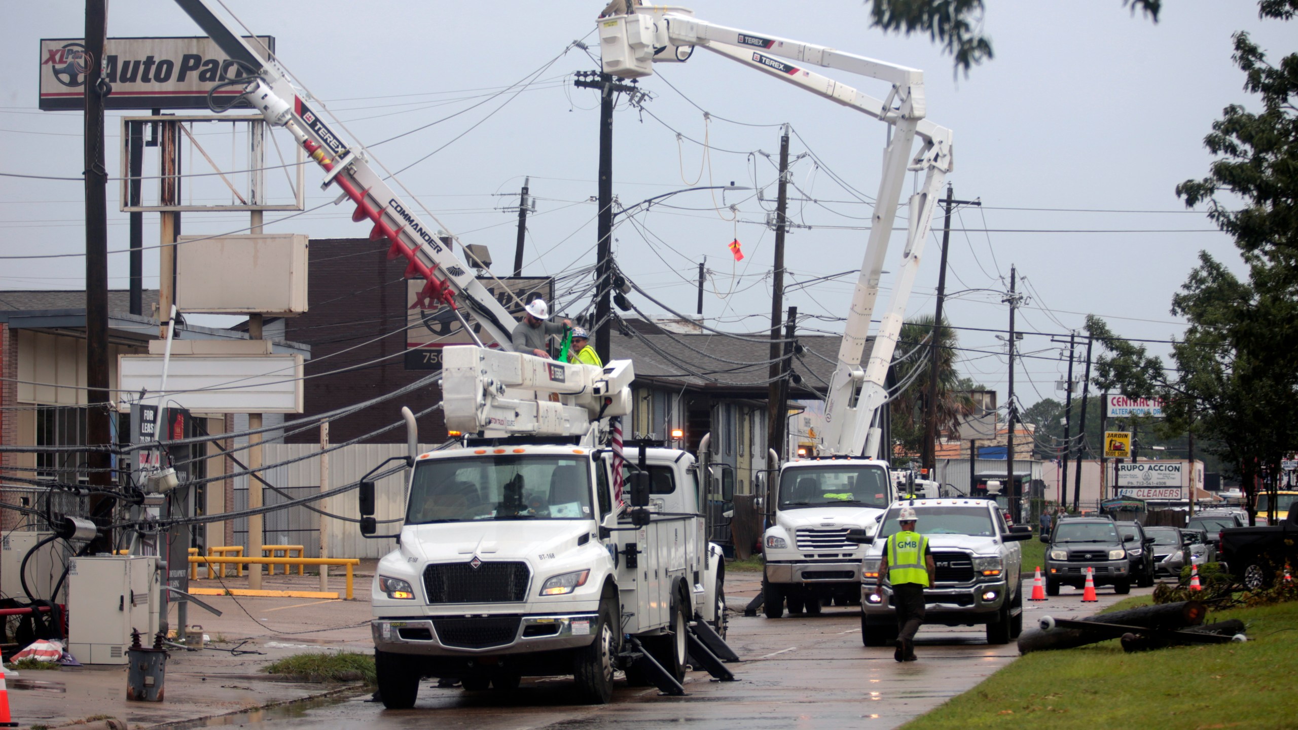 Utility crews work to restore electricity in Houston, Thursday, July 11, 2024. Officials say about 500,000 customers still won't have electricity into next week as wide outages from Hurricane Beryl persist. (AP Photo/Lekan Oyekanmi)