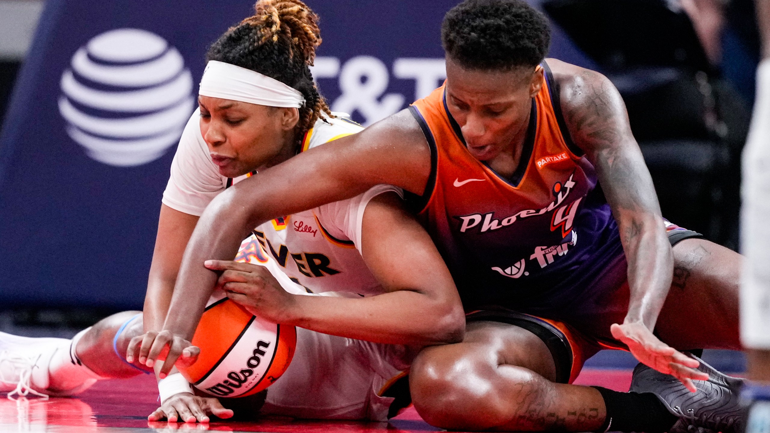 Indiana Fever forward NaLyssa Smith, left and Phoenix Mercury forward Natasha Mack (4) fight for a loose ball in the second half of a WNBA basketball game in Indianapolis, Friday, July 12, 2024. (AP Photo/Michael Conroy)