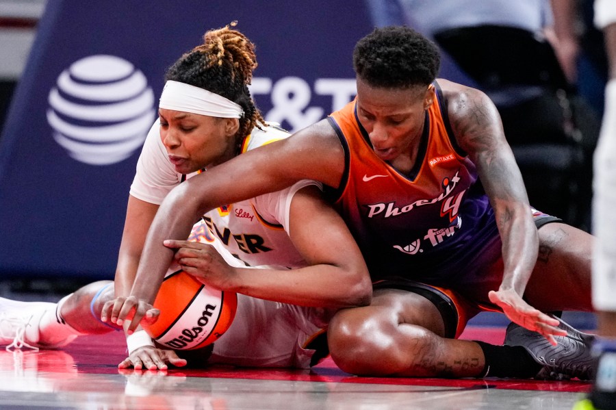 Indiana Fever forward NaLyssa Smith, left and Phoenix Mercury forward Natasha Mack (4) fight for a loose ball in the second half of a WNBA basketball game in Indianapolis, Friday, July 12, 2024. (AP Photo/Michael Conroy)