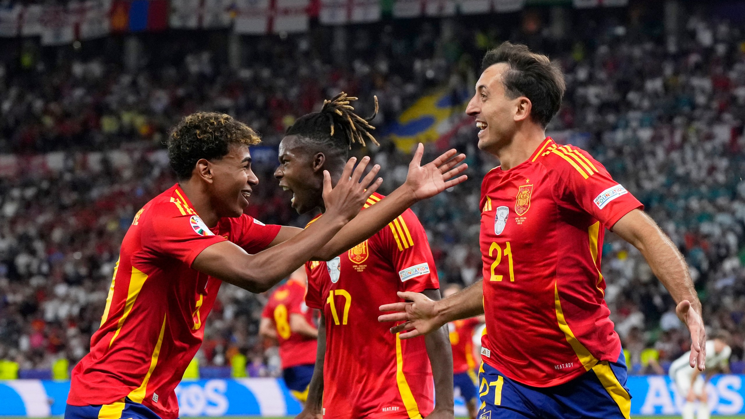 Spain's Mikel Oyarzabal, right, celebrates with Nico Williams and Lamine Yamal, left, after scoring his side's second goal during the final match between Spain and England at the Euro 2024 soccer tournament in Berlin, Germany, Sunday, July 14, 2024. (AP Photo/Manu Fernandez)