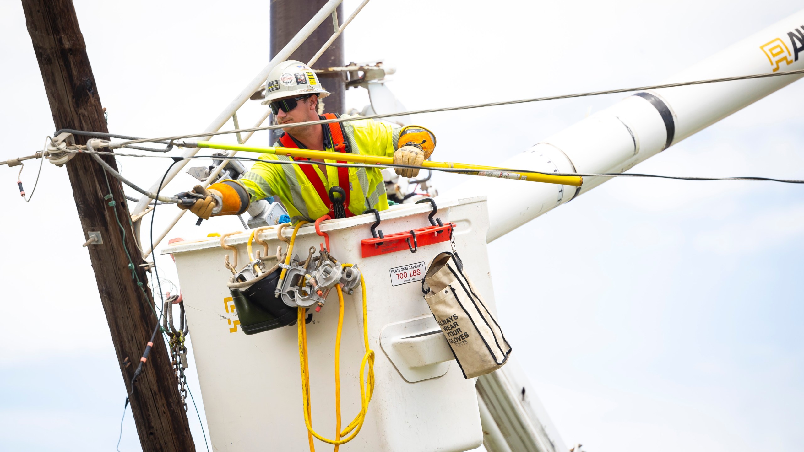 A lineman repairs a power line on Galveston Island on Saturday, July 13, 2024. (AP Photo/Annie Mulligan)