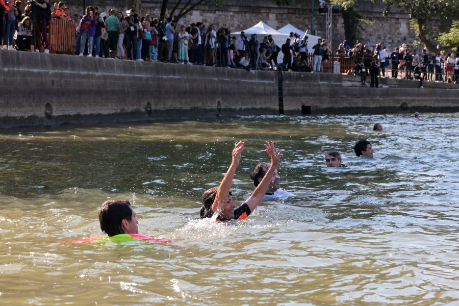 Paris Mayor Anne Hidalgo, center, swims in the Seine river, Wednesday, July 17, 2024 in Paris. After months of anticipation, Paris Mayor Anne Hidalgo took a dip in the Seine River on Wednesday, fulfilling a promise she made months ago to show the river is clean enough to host open-swimming competitions during the 2024 Olympics — and the opening ceremony on the river nine days away.(Joel Saget, Pool via AP)