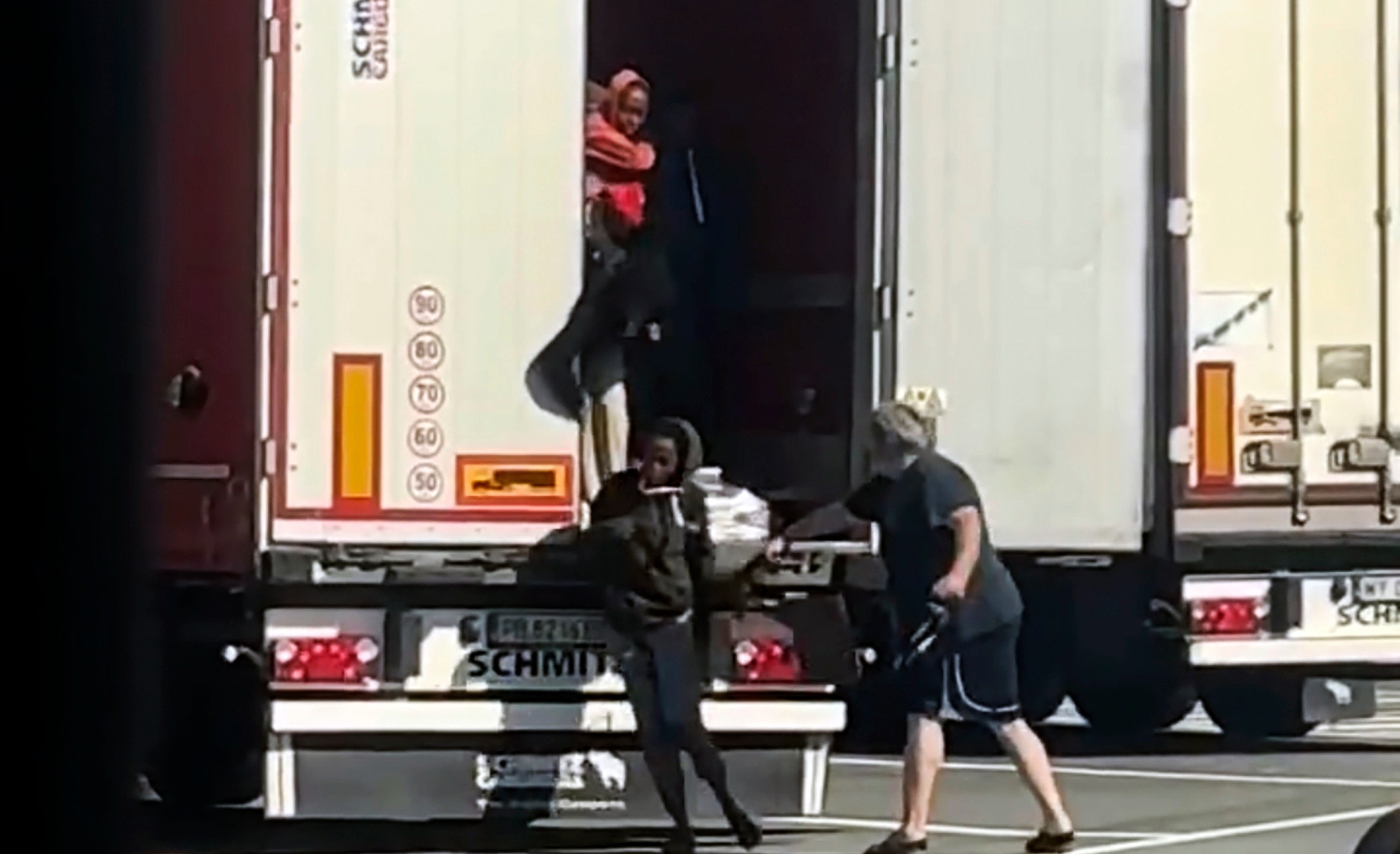 In this frame grab taken from a truck driver strikes female migrants with the hardware end of a cargo strap as they exited from the back of his truck at rest stop near the French border in Ventimiglia, Monday, July 15, 2024. According to authorities, smugglers loaded the 12 Eritrean women on to the back of the truck at a rest stop near the French border on Monday while the trucker was having lunch. Once closed inside the truck, the women apparently started agitating due to the heat, with outdoor temperatures over 30 degrees, drawing the driver's attention, city officials said. While the truck driver was being sought, officials said he was unlikely to face any sanction as it would require the women to make a formal complaint. (UGC via AP)