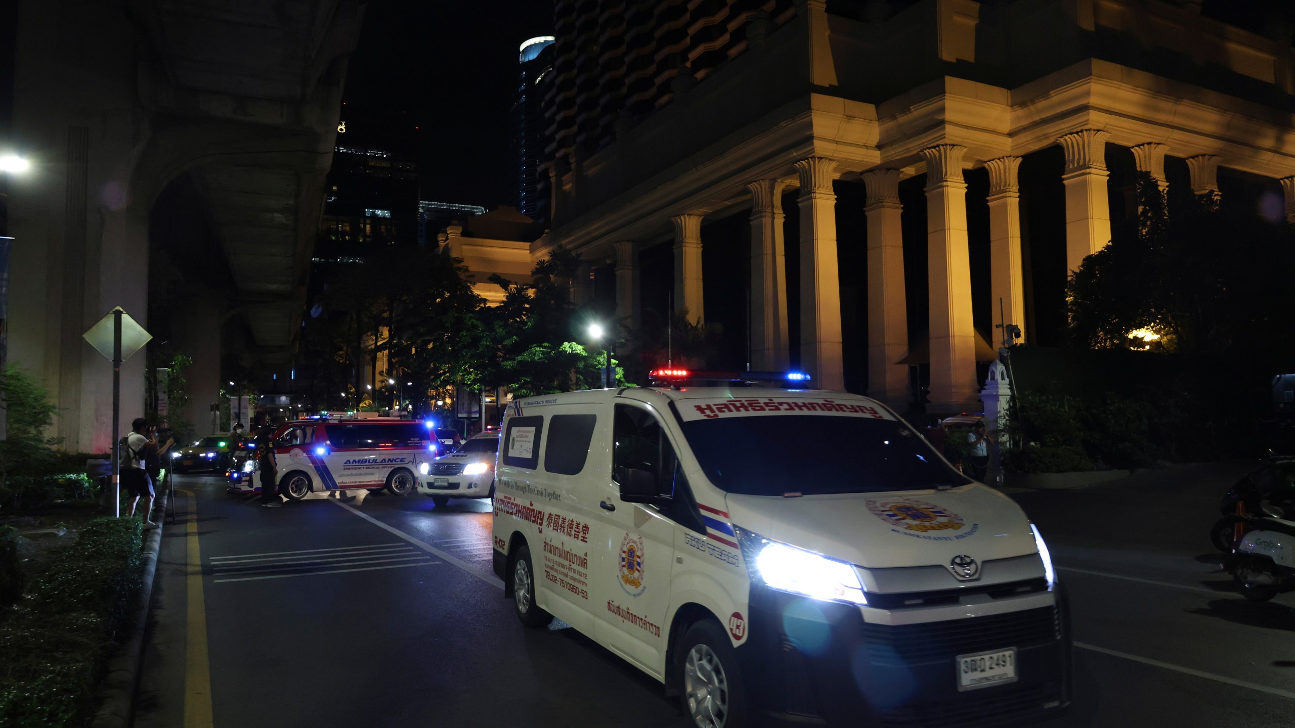 An ambulance sits outside the Grand Hyatt Erawan Hotel to Chulalongkorn hospital in Bangkok, Thailand, Tuesday, July 16, 2024. Police say the bodies of six people were found in the luxury hotel in downtown Bangkok. (AP Photo/Chatkla Samnaingjam)