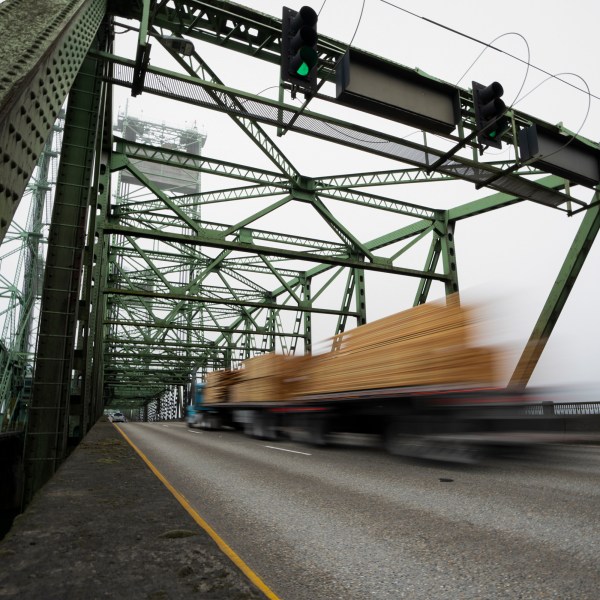 FILE - A logging truck drives on the Interstate 5 bridge that spans the Columbia River and connects Portland, Ore., with southwest Washington state, Feb. 13, 2024. Dozens of aging bridges, including this Interstate 5 bridge, in 16 states will be replaced or improved with the aid $5 billion of federal grants announced Wednesday, July 17, by President Joe Biden's administration as the latest beneficiaries of a massive infrastructure law. (AP Photo/Jenny Kane, File)