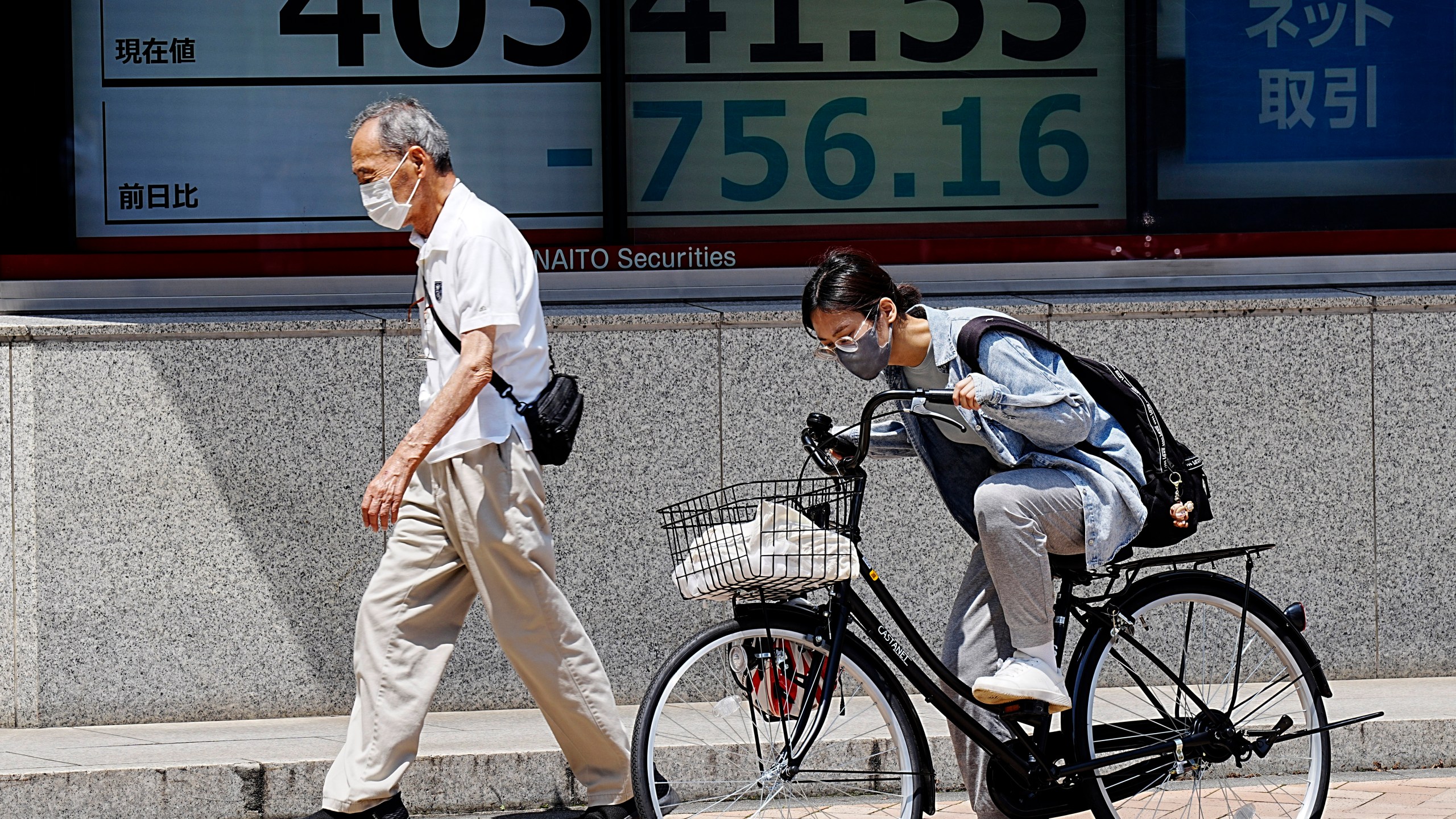 A person walks in front of an electronic stock board showing Japan's Nikkei 225 index at a securities firm, Thursday, July 18, 2024, in Tokyo. (AP Photo/Eugene Hoshiko)