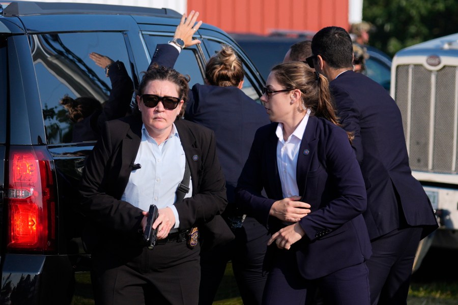 FILE - U.S. Secret Service agents surround the vehicle carrying Republican presidential candidate former President Donald Trump at a campaign rally, Saturday, July 13, 2024, in Butler, Pa. (AP Photo/Evan Vucci, File)