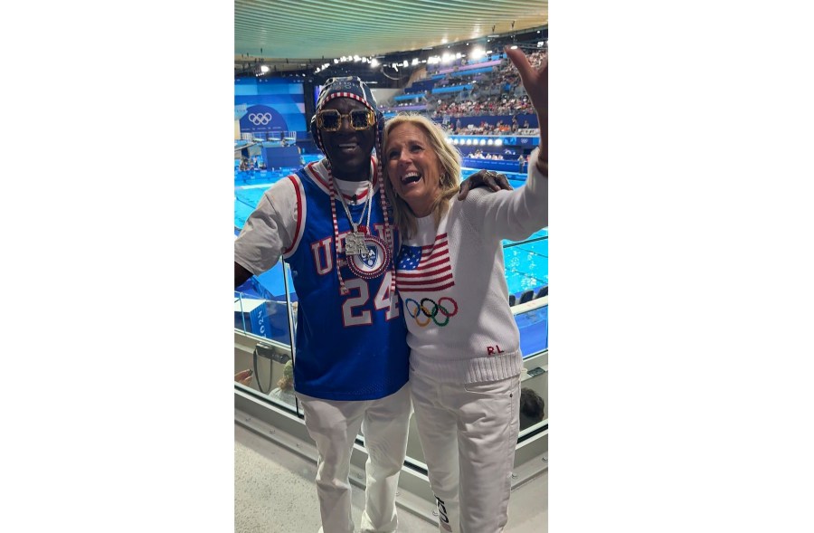 In this photo provided by Rhiannon Rae Ellis on Saturday, July 27, 2024, U.S. First Lady Jill Biden poses for a photo with Flavor Flav during a women's Water Polo match, at the 2024 Summer Olympics, Saturday, July 27, 2024, in Saint-Denis, France. (Rhiannon Rae Ellis via AP)